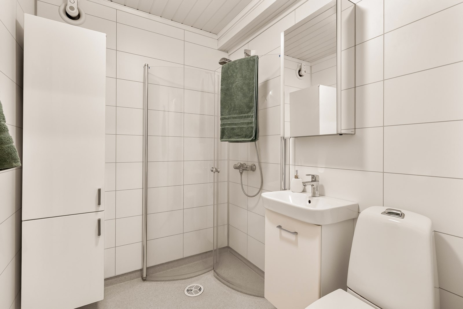 Badet ble renovert i 2017. Veggene er kledd med baderomsplater som gir et stilrent og vedlikeholdsvennlig uttrykk, mens taket har malt panel.
Gulvet er belagt med vinyl og har elektriske varmekabler Galleribilde