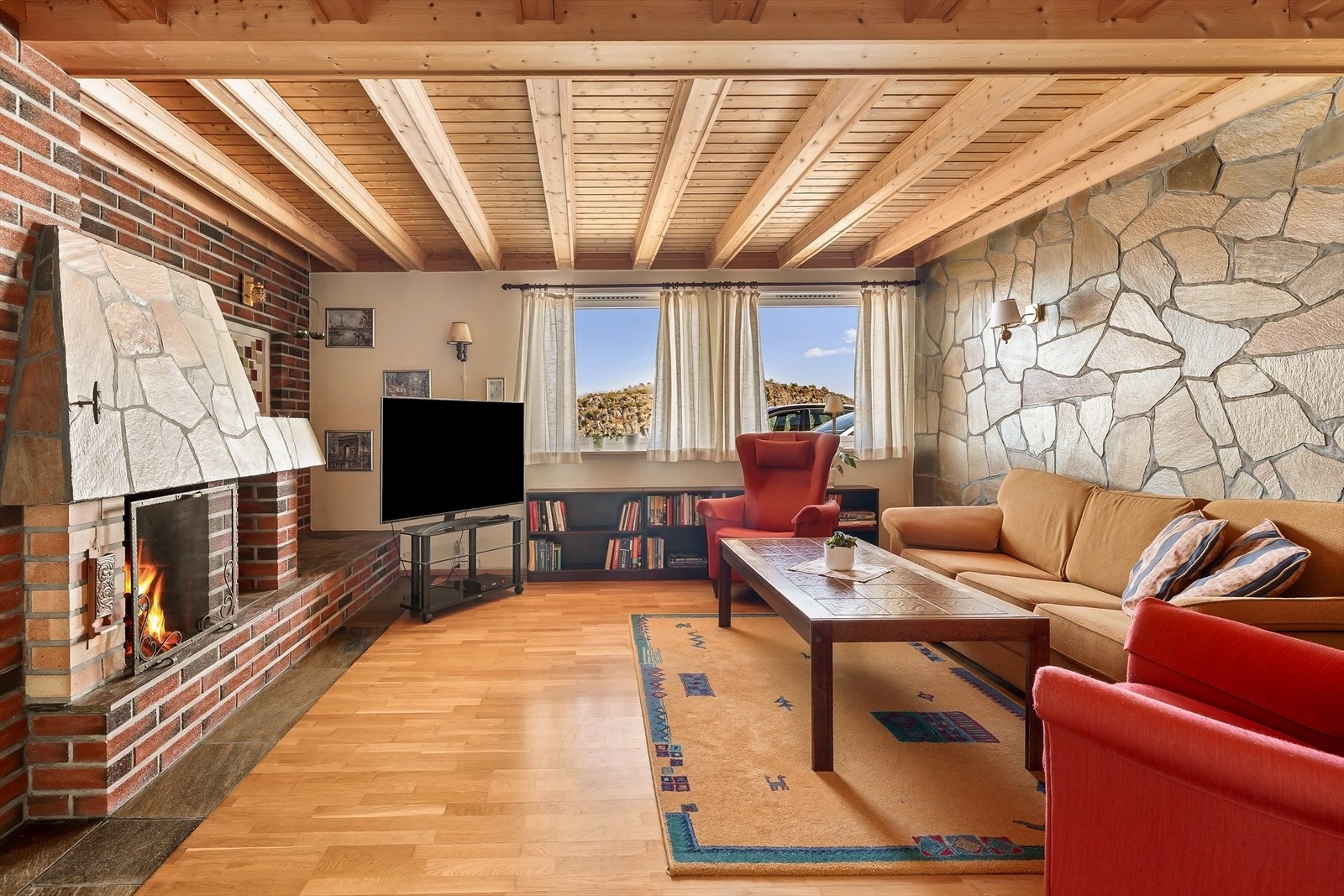 Peisestuen fremstår som et særdeles stemningsfullt og innbydende rom, med en nydelig håndlaget skifervegg som gir et eksklusivt og karakterfullt uttrykk. Den solide utførelsen og de naturlige materialene skaper en lun og varm atmosfære. Galleribilde