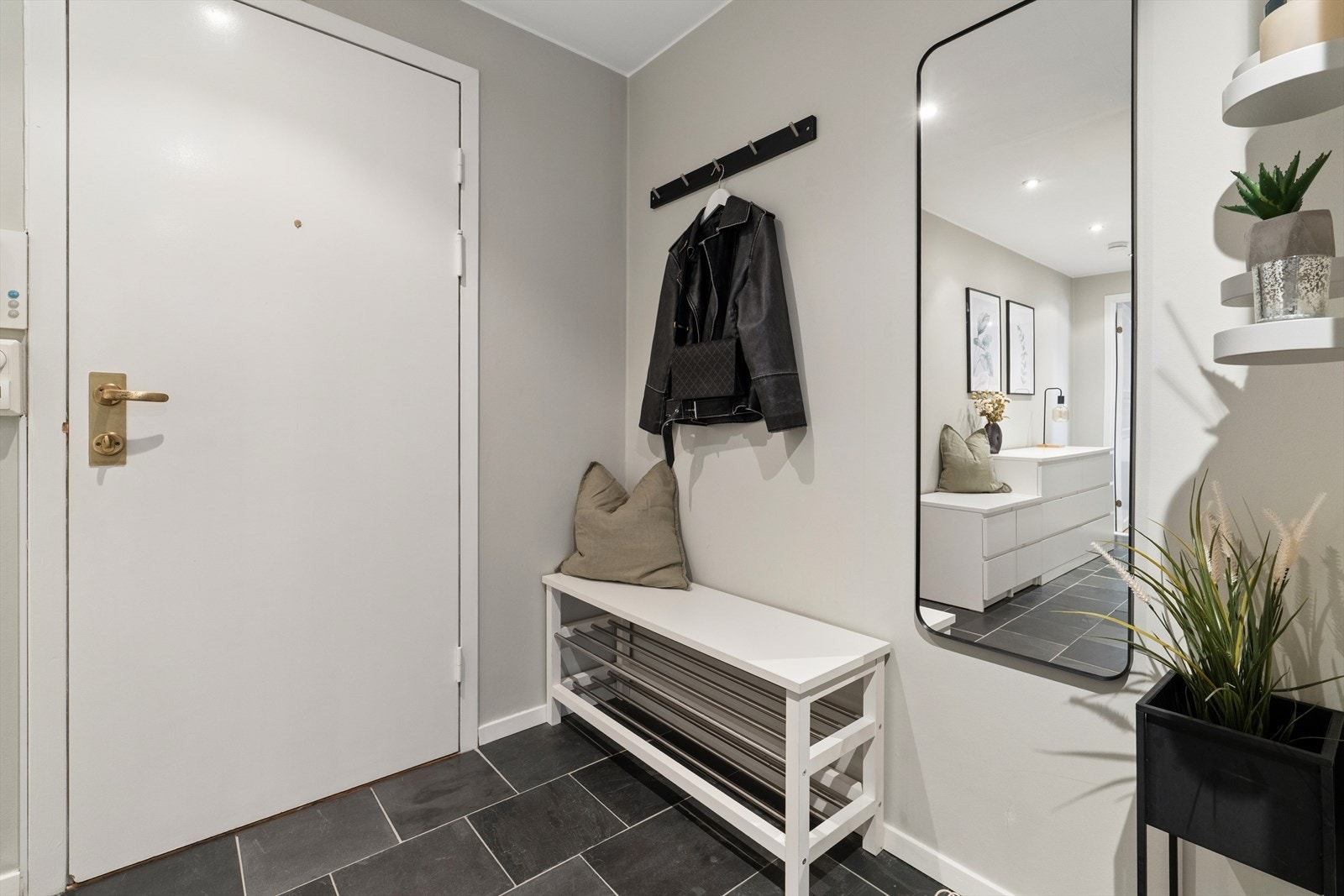 Her ønskes man inn i en lys og praktisk entré med opphengsløsning på vegg for jakker og plass til å sette fra seg sko. Galleribilde