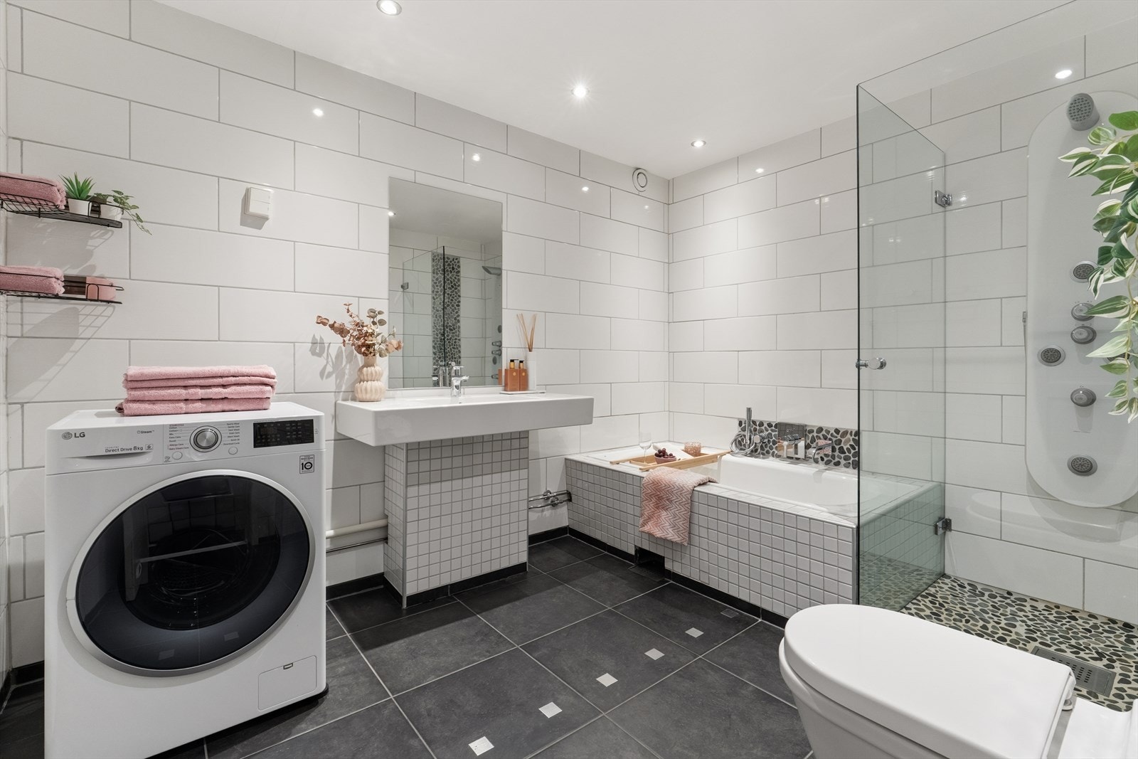 Badet fremstår som praktisk og innbydende, med flislagte vegger og gulv som gir et tidløst uttrykk. Elektriske varmekabler i gulvet. Galleribilde