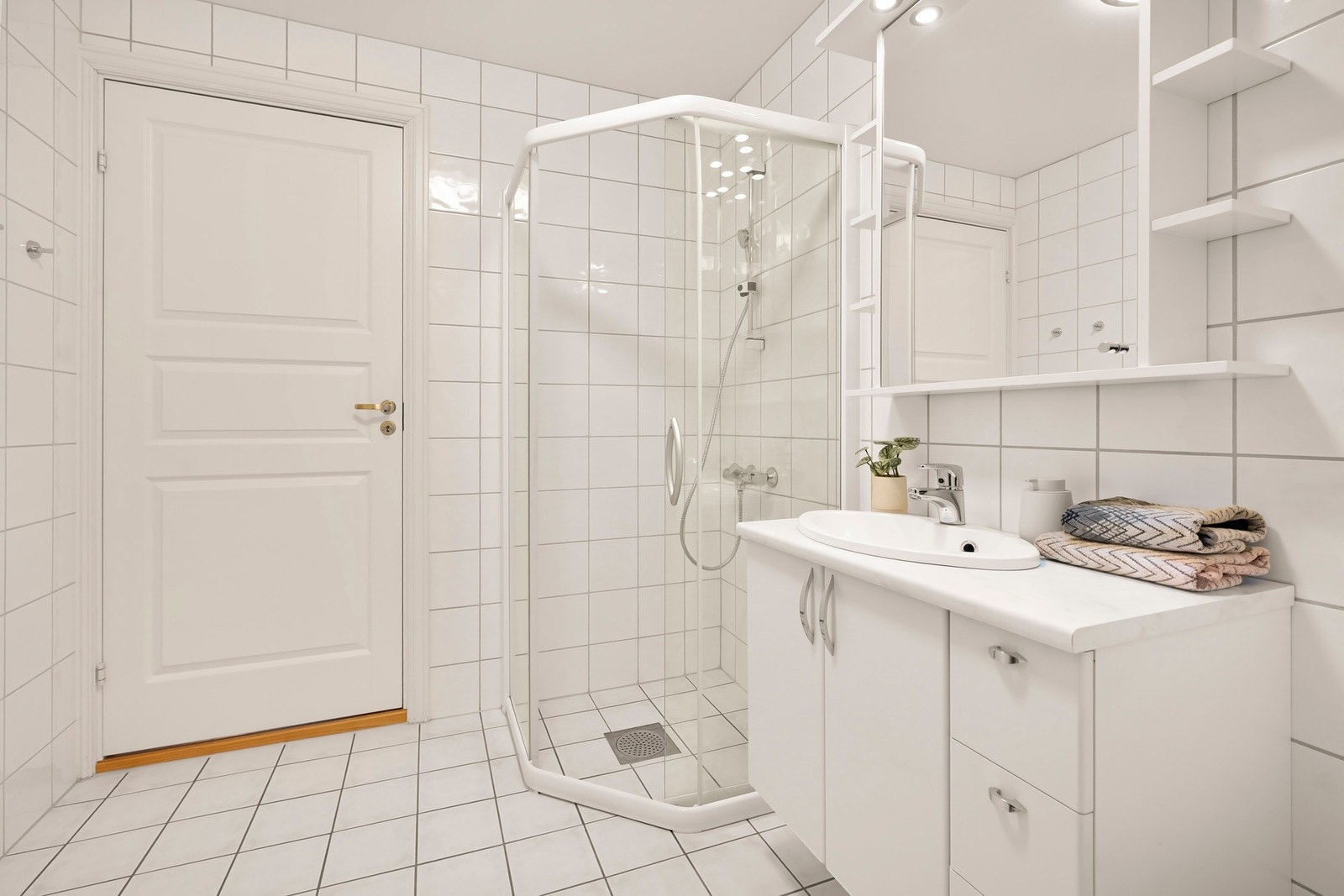 Badet har servantinnredning med skap og skuffer, samt speilskap med belysning på vegg. Galleribilde