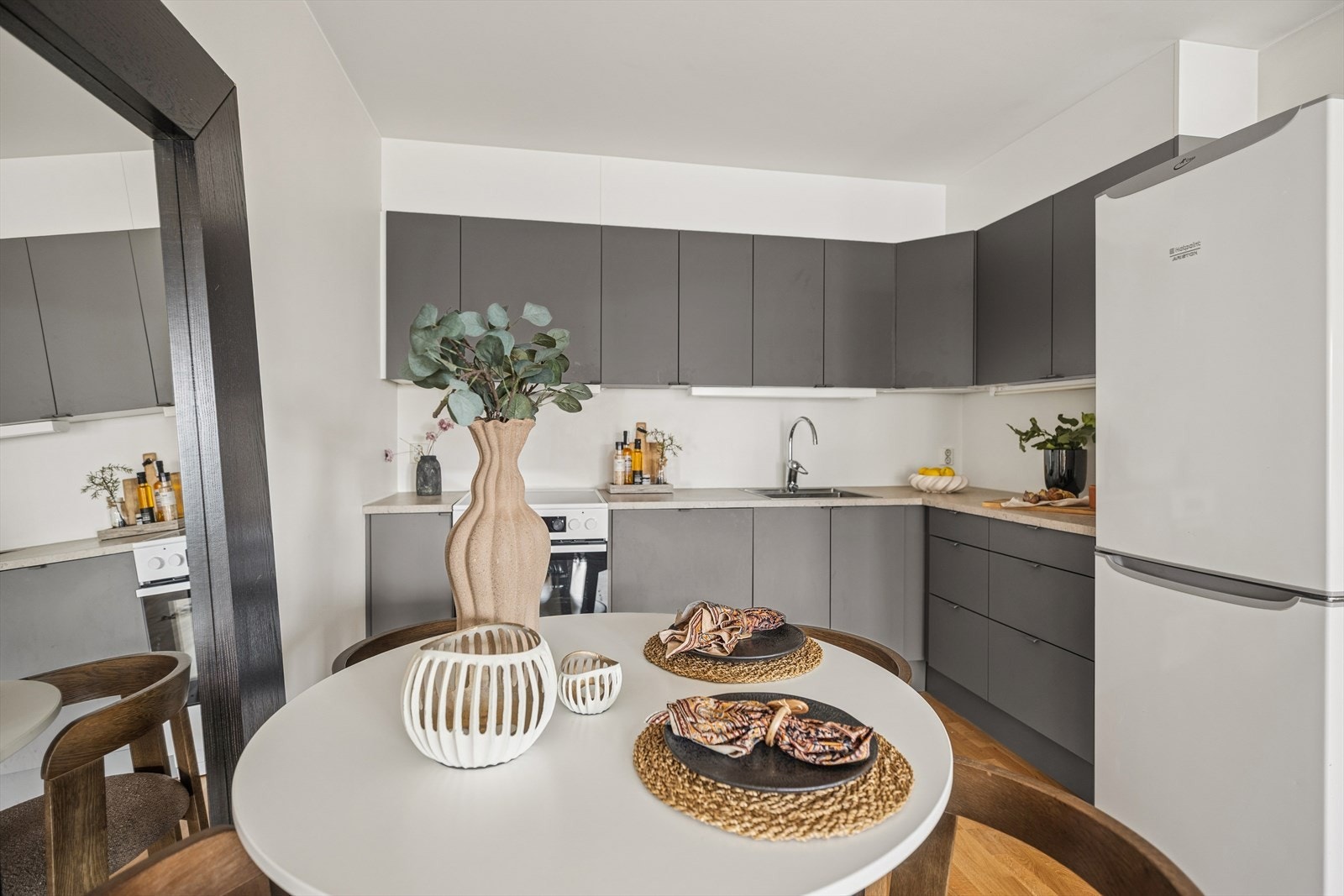 Kjøkkenet er i kombinasjon med stuen og har grå, glatte fronter og laminat benkeplate med oppvaskkum i rustfritt stål. Galleribilde