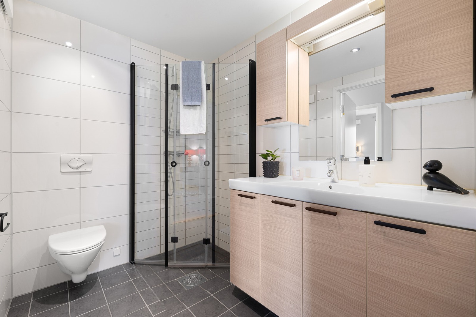 Leilighetens baderom har fliser på gulv og vegg. Badet holdes godt og varmt året rundt, ved bruk av elektriske varmekabler i gulv. Galleribilde