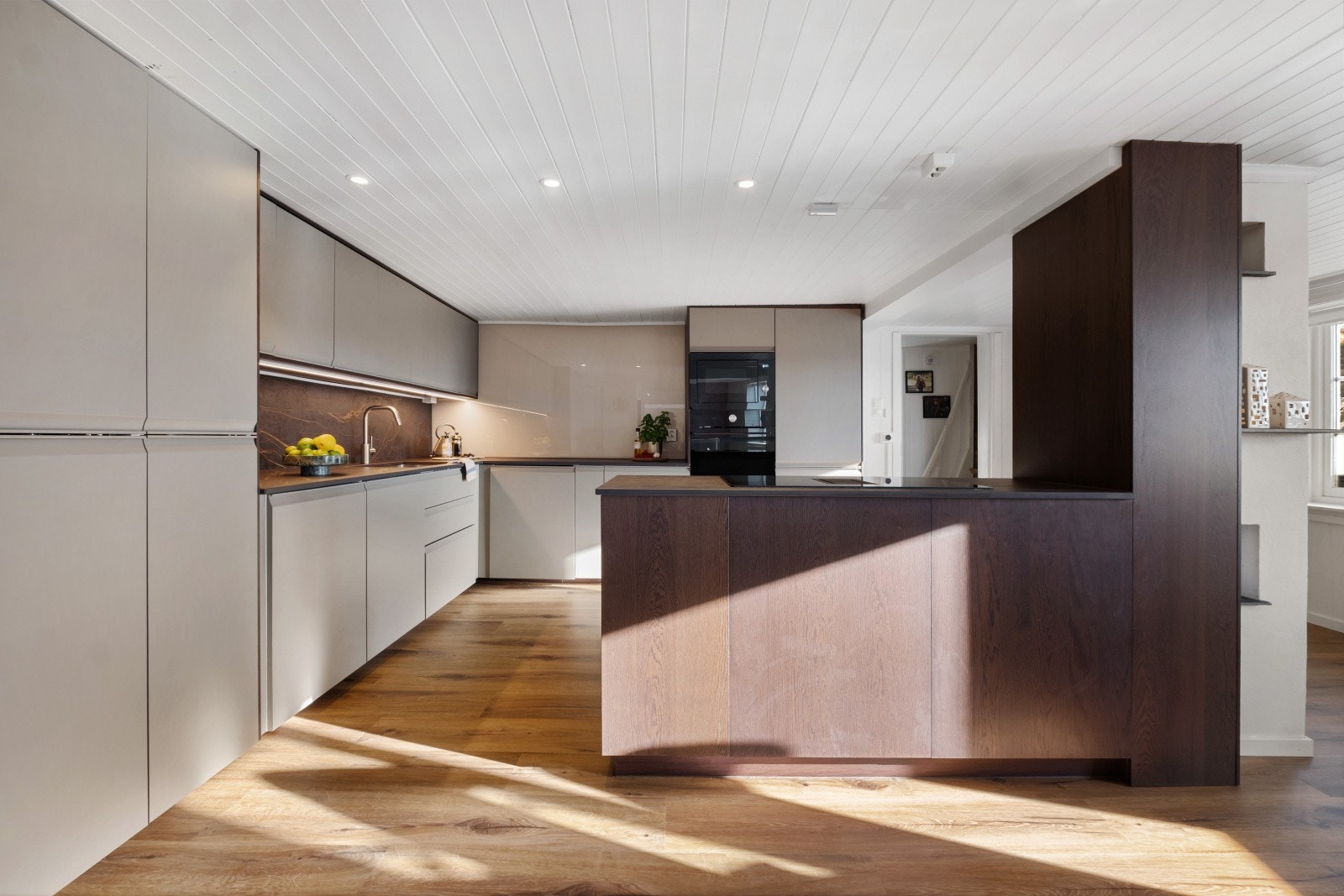 Kjøkkenet er videre utstyrt med nedfelt stålvask, kitchenboard på vegg over benk samt integrerte hvitevarer, inkludert komfyr, mikro, koketopp og kjøl-/fryseskap Galleribilde