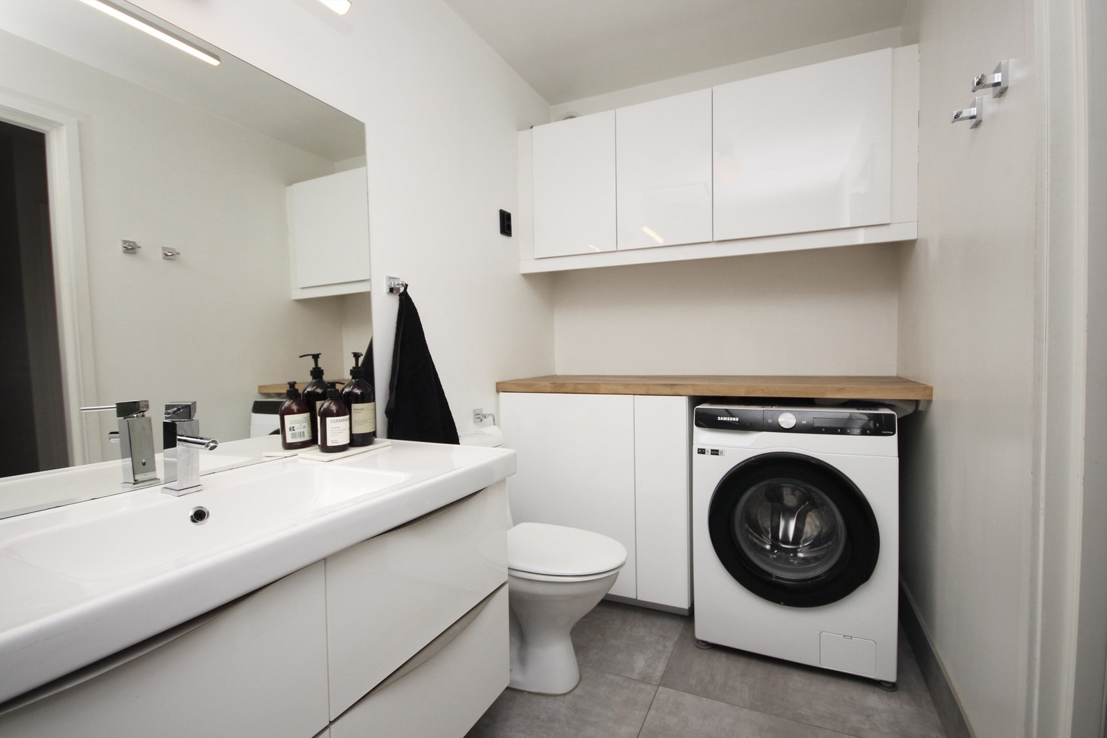 Praktisk plass til vaskemaskin og godt med oppbevaring på badet. Galleribilde