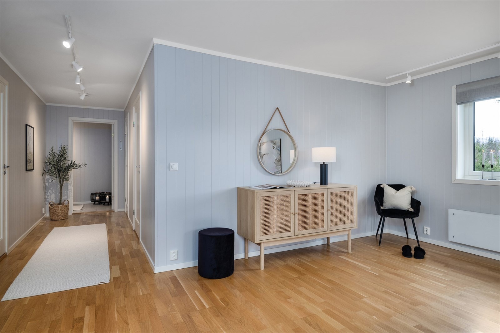 Fra entréen åpner det seg en romslig gang med parkettgulv som leder videre inn i leiligheten. Galleribilde