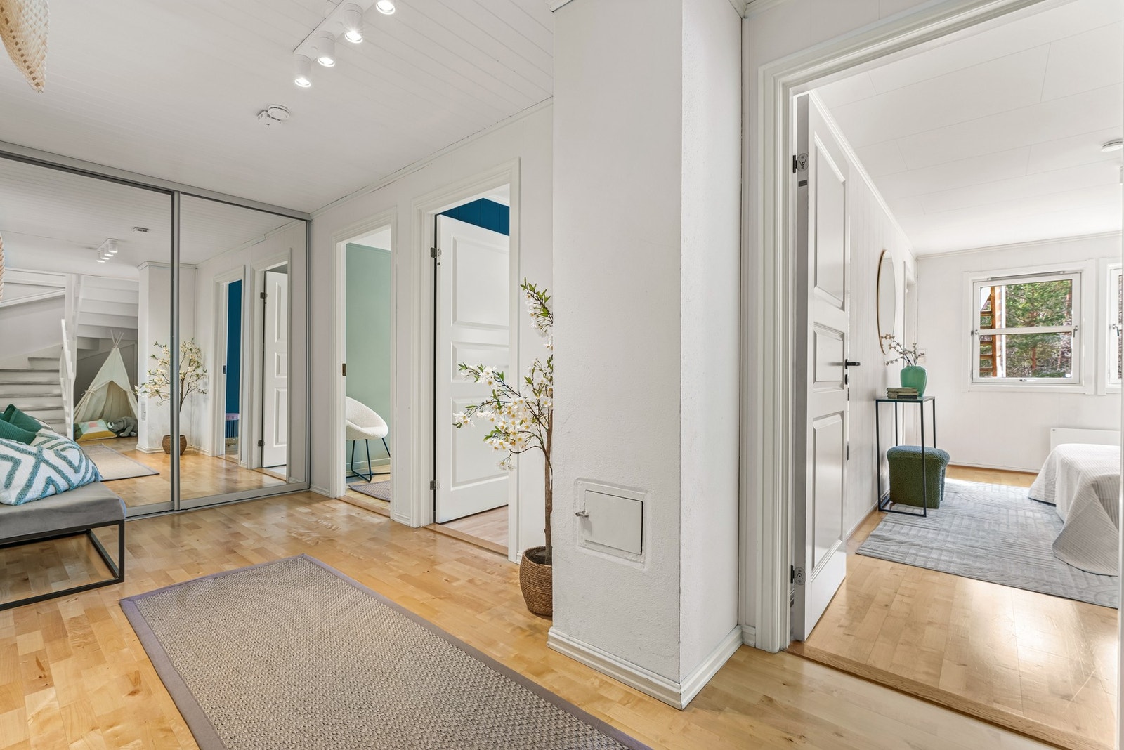 Romslig gang/trapperom i underetasjen med en stor skyvedørsgarderobe med speilfronter Galleribilde