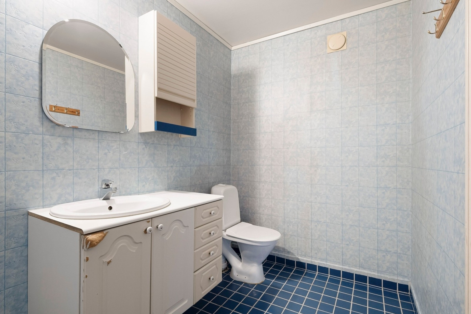 Badet har servantinnredning med skuffer og skap, samt speil på vegg over servant. Galleribilde