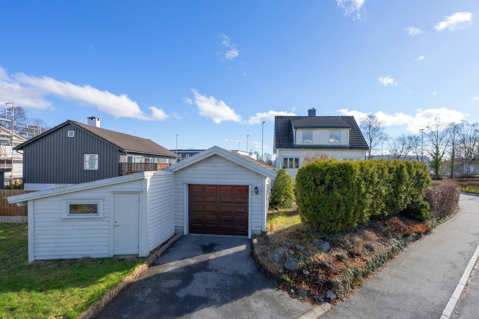 Garasje med montert elbillader. Det er en tilhørende redskapsbod til garasjen, totalt 30 kvm med ekstra plass. Galleribilde