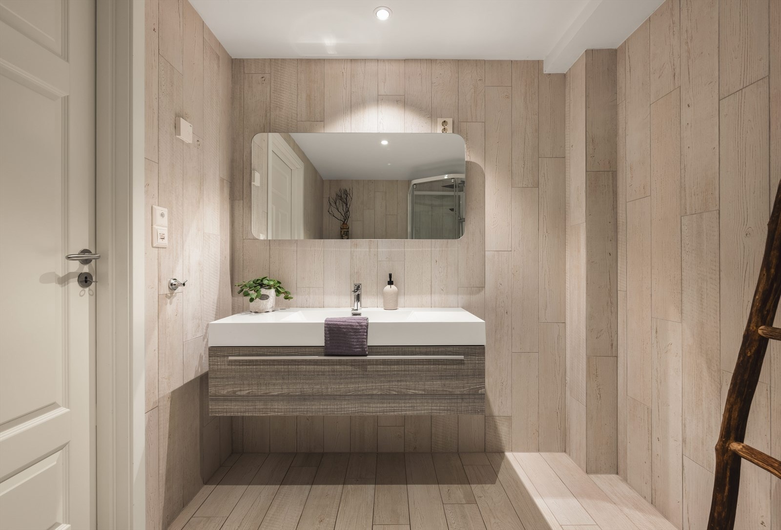 Badet er utstyrt med moderne baderomsinnredning, veggmontert toalett og dusjkabinett, samt elektrisk styrt vifte Galleribilde
