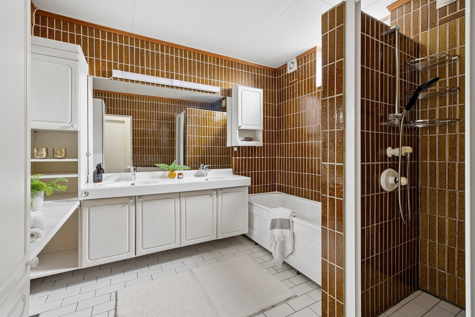 Badet i underetasjen er fra byggeåret og er innredet med badekar, dusjnisje og en dobbel servant med underskap. Galleribilde
