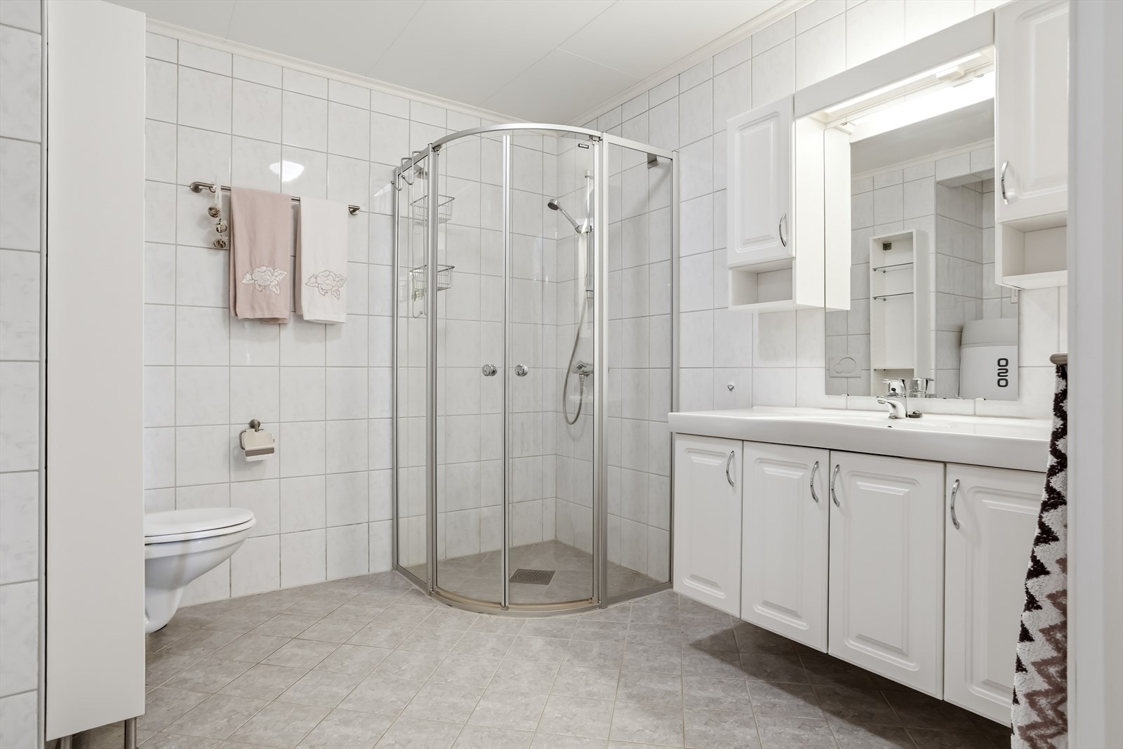 Helfliset bad som er innredet med WC, dusjhjørne, servant med underskap og vegghengt skap. Det er også opplegg til vaskemaskin. Galleribilde
