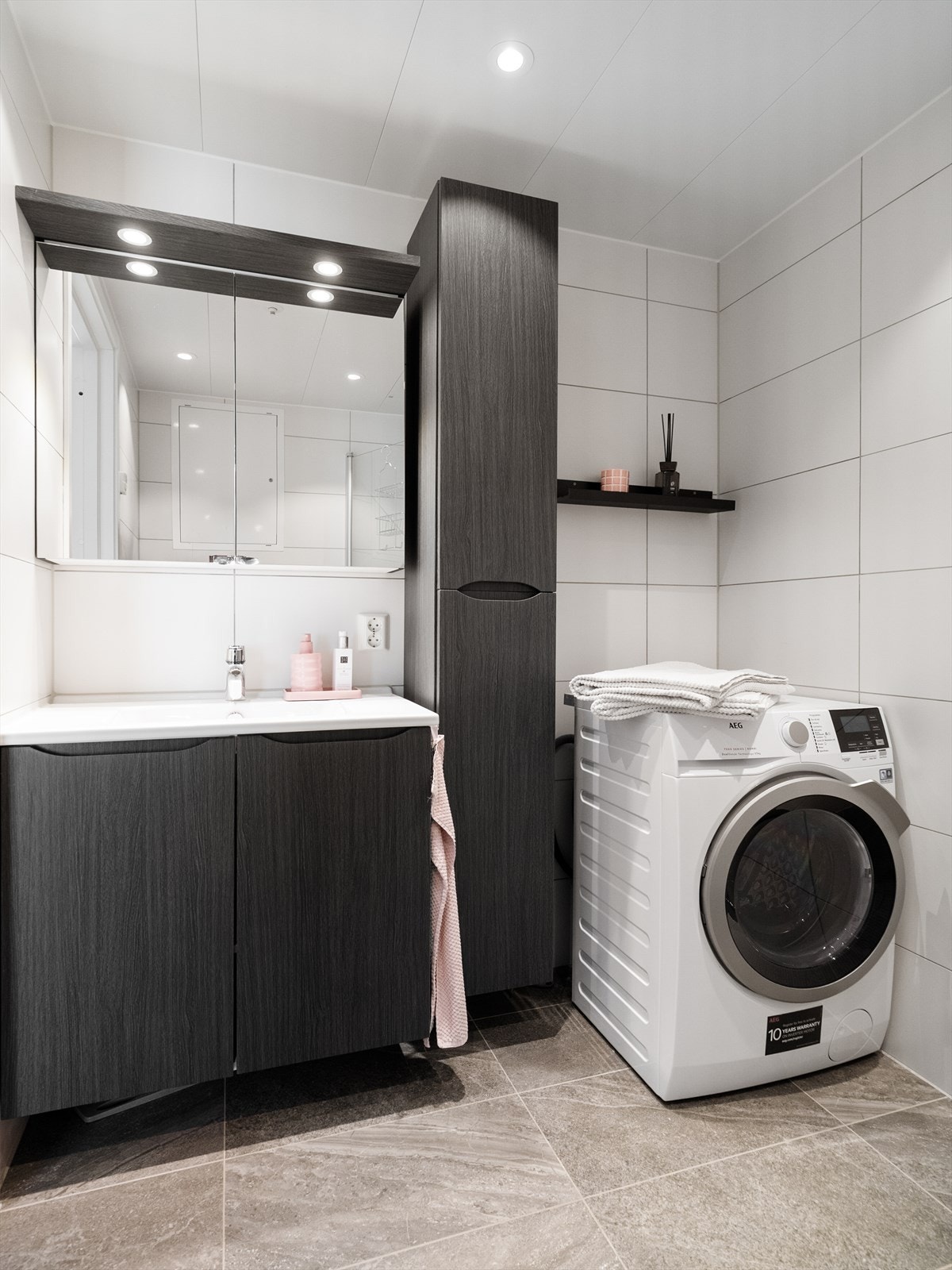 Badet er praktisk innredet med blant annet dusjhjørne med foldbare glassdører og opplegg for vaskemaskin. Galleribilde