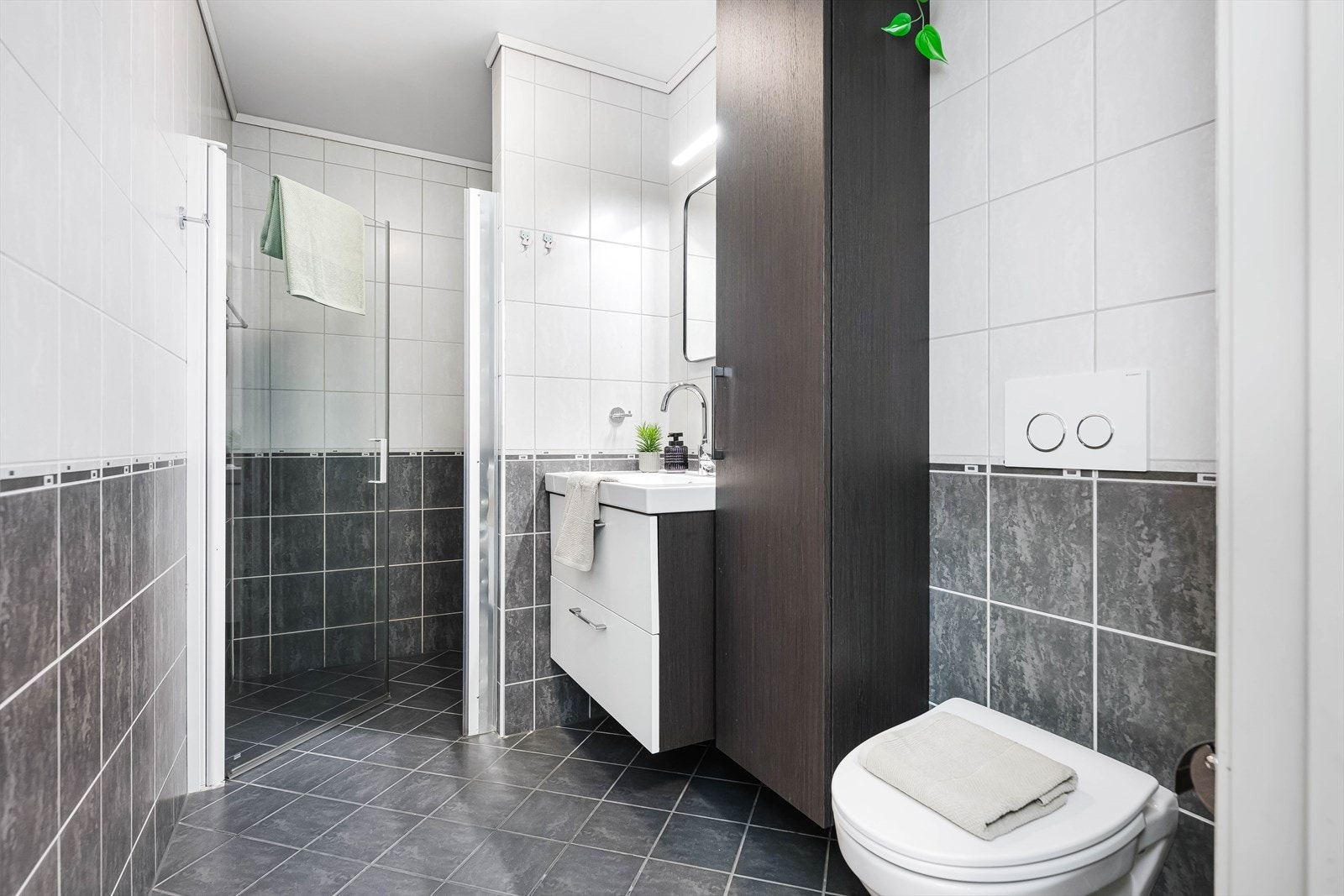 Badet i hovedetasjen er pent og helfliset, med innredning som dusjnisje, servantinnredning med skuffer og veggskap samt vegghengt klosett. Galleribilde