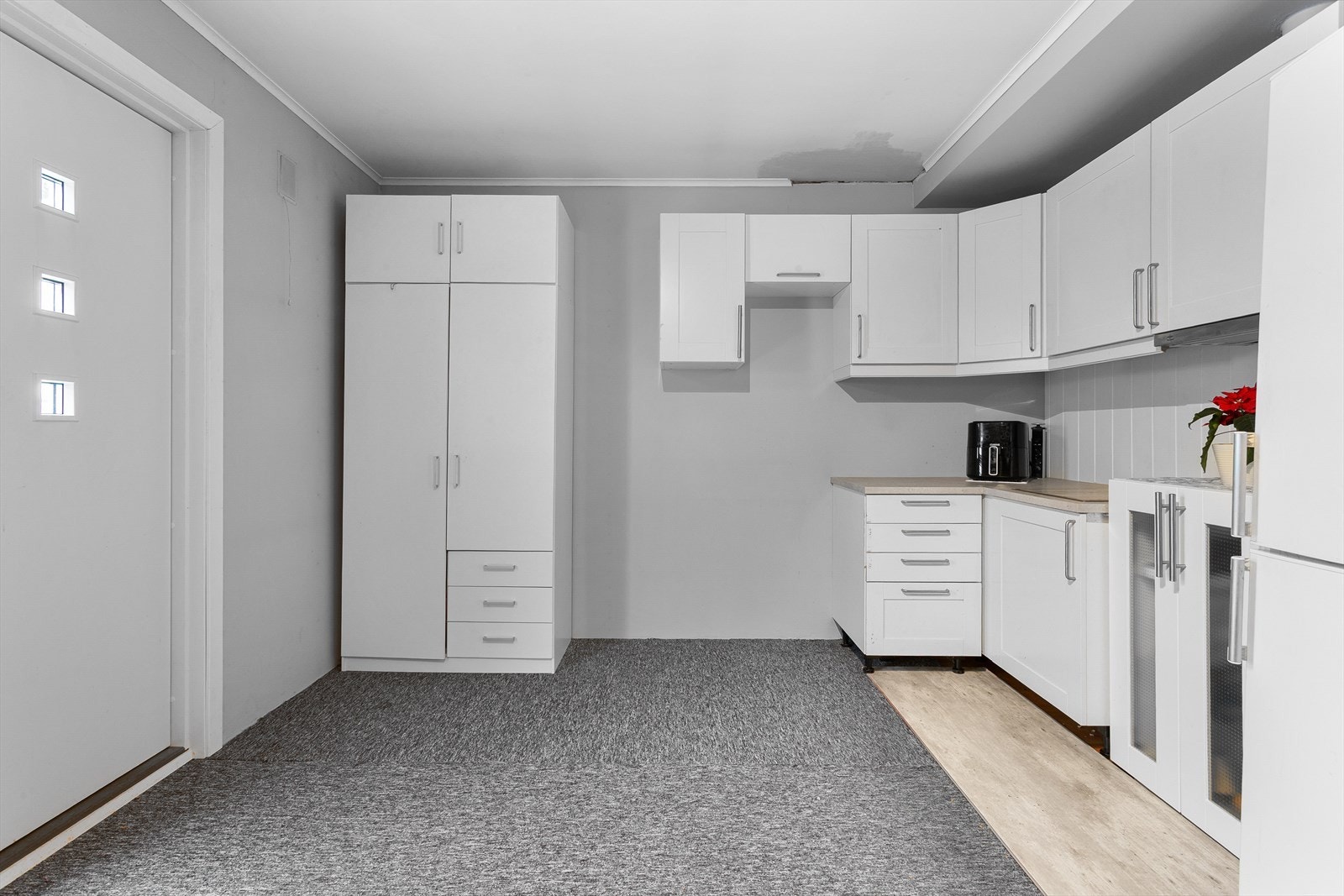 Denne delen har et eget hybelkjøkken med glatte fronter, laminatbenkeplate og kjøkkenventilator. Galleribilde