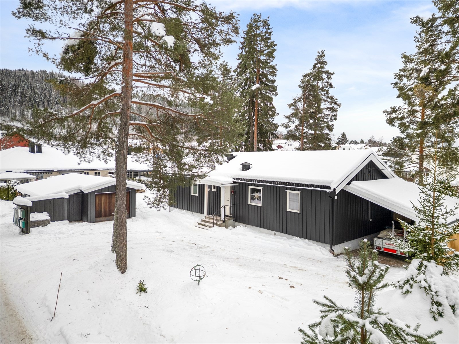 I tillegg til boligen får du en romslig, uisolert garasje på 43 m² og et drivhus fra 2021. Eiendommen ligger i et rolig nabolag med kort vei til skog og mark. Galleribilde