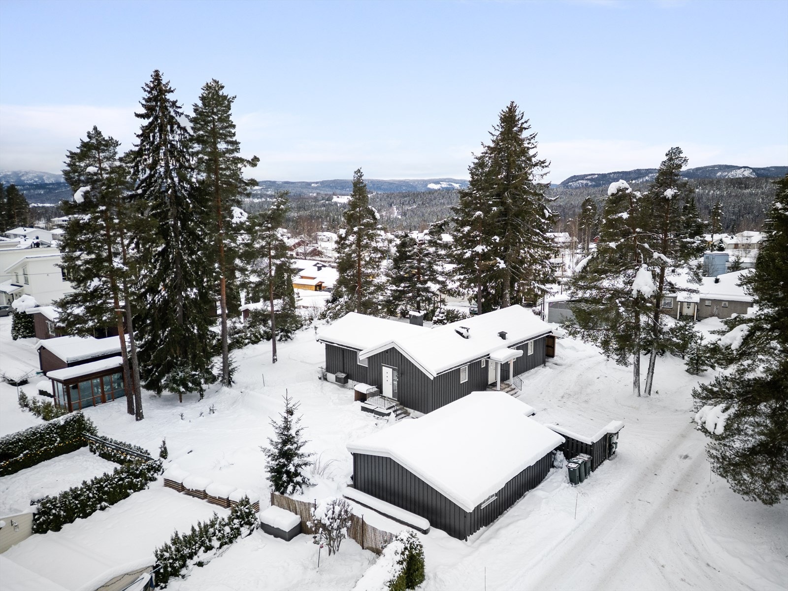 Oversikt over eiendommen med bolighus, garasje og drivhus. Galleribilde
