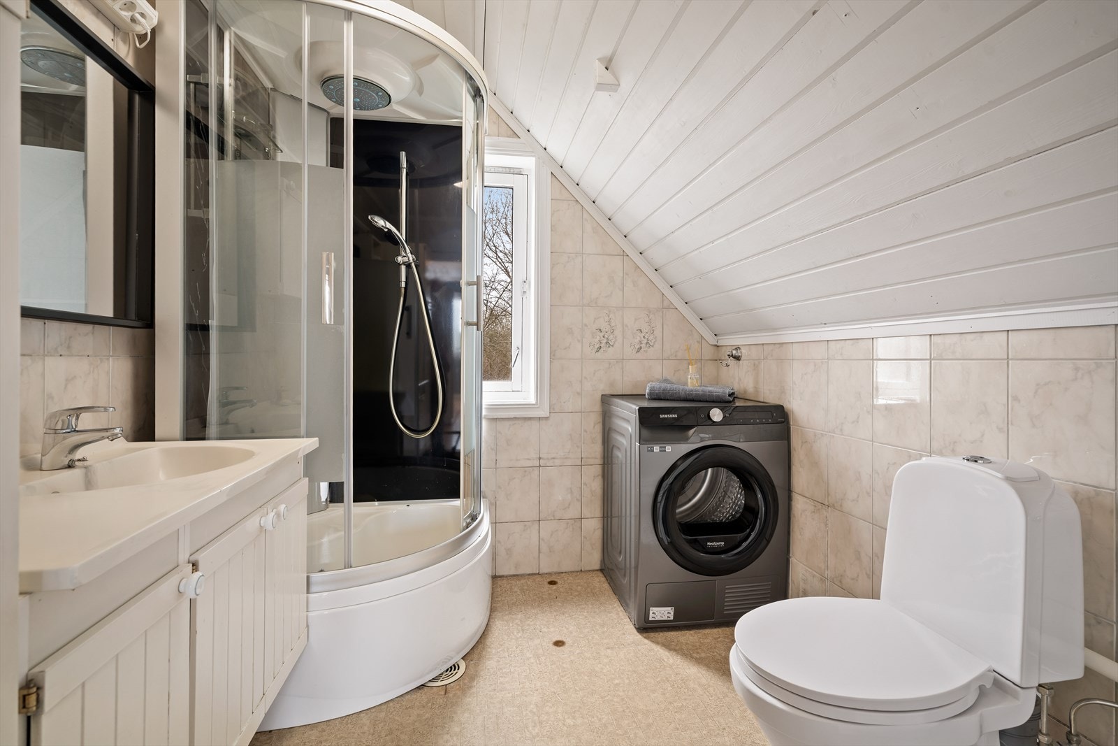 Badet i 2. etasje har flislagte vegger og belegg på gulv. Det er opplegg for vaskemaskin på badet. Galleribilde
