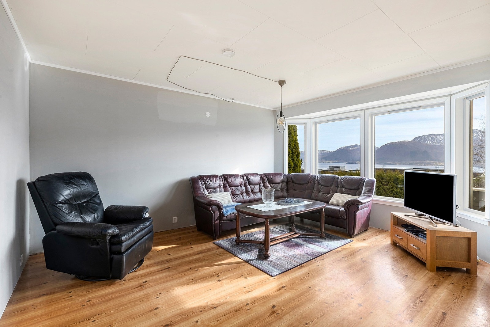 Romslig og lys stue med store vindusflater for godt med dagslys. Galleribilde