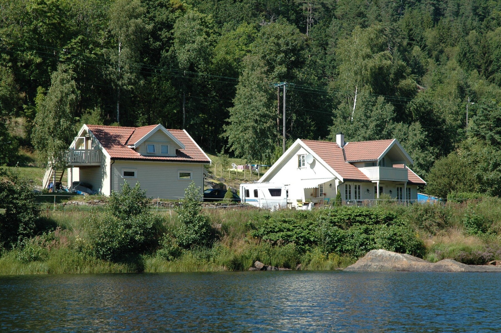 Selgers bilde fra elva mot huset og garasjen Galleribilde