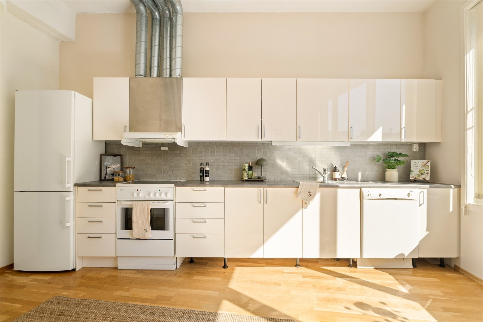 Kjøkkeninnredningen har hvite glatte fronter og laminert benkeplate, og det godt med skap- og benkeplass, samt plass til en spisegruppe. Galleribilde