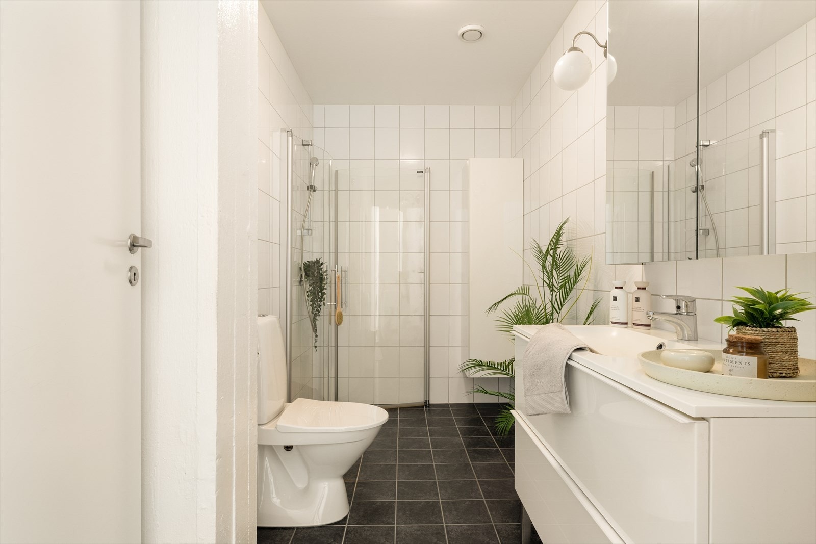 Badet er pent flislagt og er på ca. 5,3 m², med varmekabler i gulv, dusjløsning, toalett og baderomsinnredning. Galleribilde