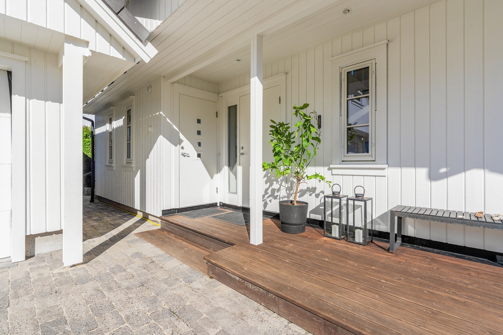 Inngangspartiet eler delvis overbygget, slik at man kan gå skjermet fra garasje og til boligen. Galleribilde