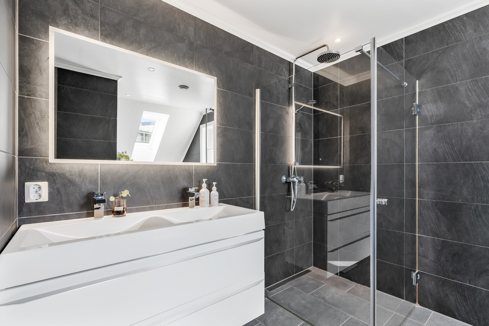 Badet er innredet med med dobbel nedsenket vask, dusjhjørne og vegghengt toalett. Galleribilde