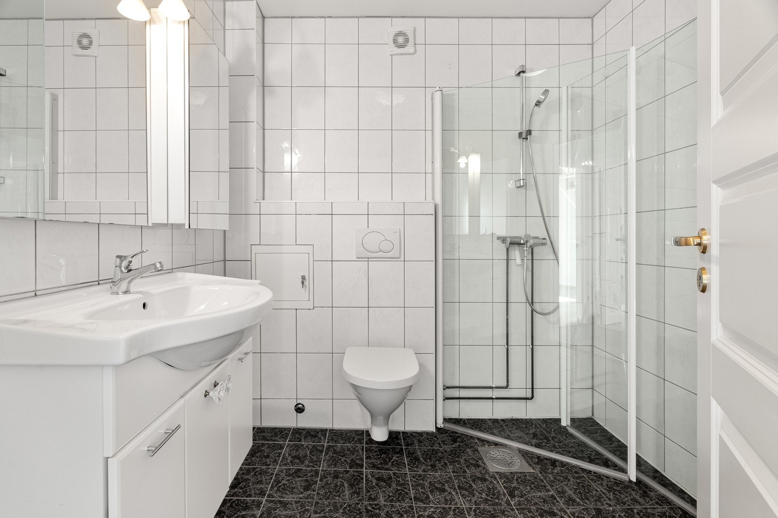 Komplett flislagt bad med hjørnedusj.