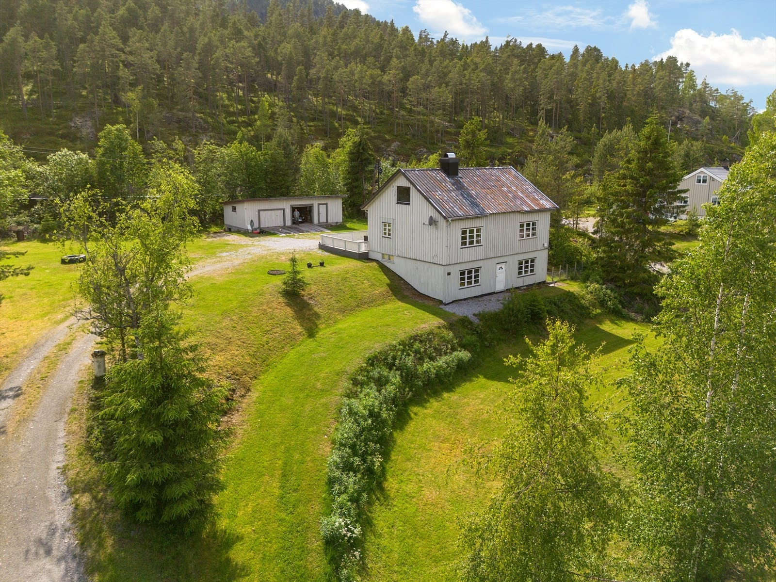 På tunet står det også en garasje med garasjerom, bod og vedbod, samt et uinnredet kjellerrom. Galleribilde