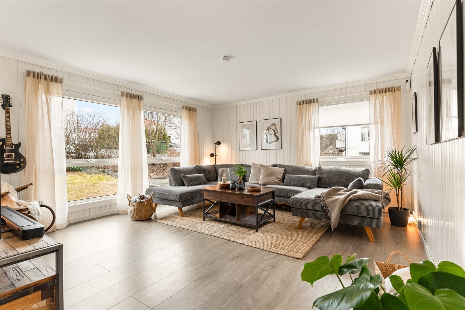 Lys og innbydende stue med store vindusflater som slipper naturen inn. Galleribilde