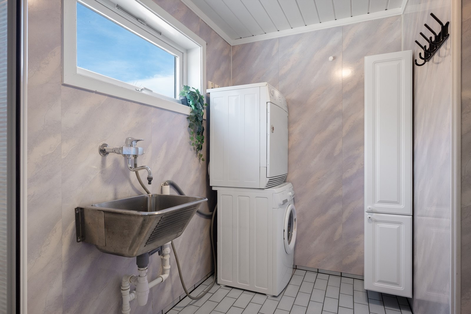 Badet er kombinert vaskerom, med opplegg for vaskemaskin. Vegger med baderomsplater og panel i taket. Rommet ventileres med en elektrisk styrt vifte. Galleribilde