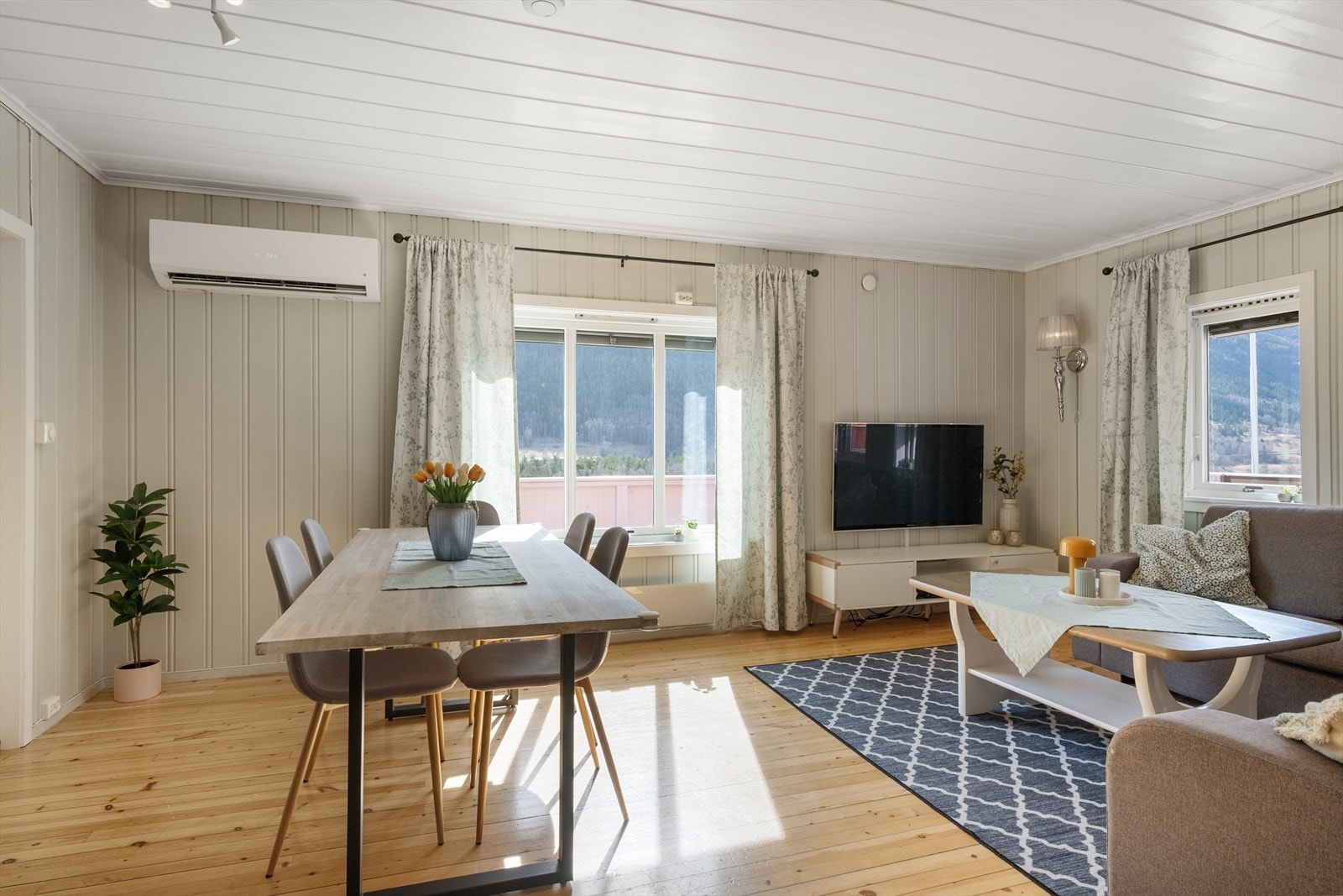Stuen er romslig og har plass til både spisebord og en større sofagruppe. Her er det installert varmepumpe av nyere dato som bidrar til effektiv oppvarming av boligen. Galleribilde