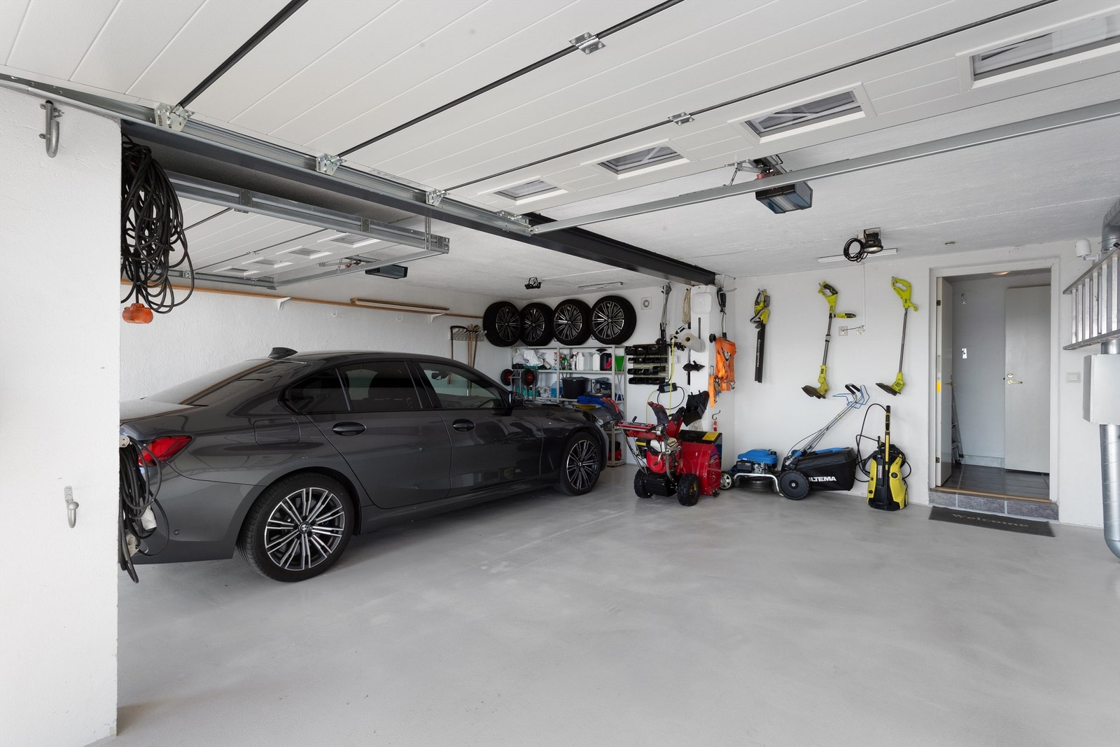 Parkering i integrert dobbelgarasje på ca. 42 kvm med epoxy-dekke på gulv og to Hörmann garasjeporter med elektriske portåpnere (2020). Galleribilde
