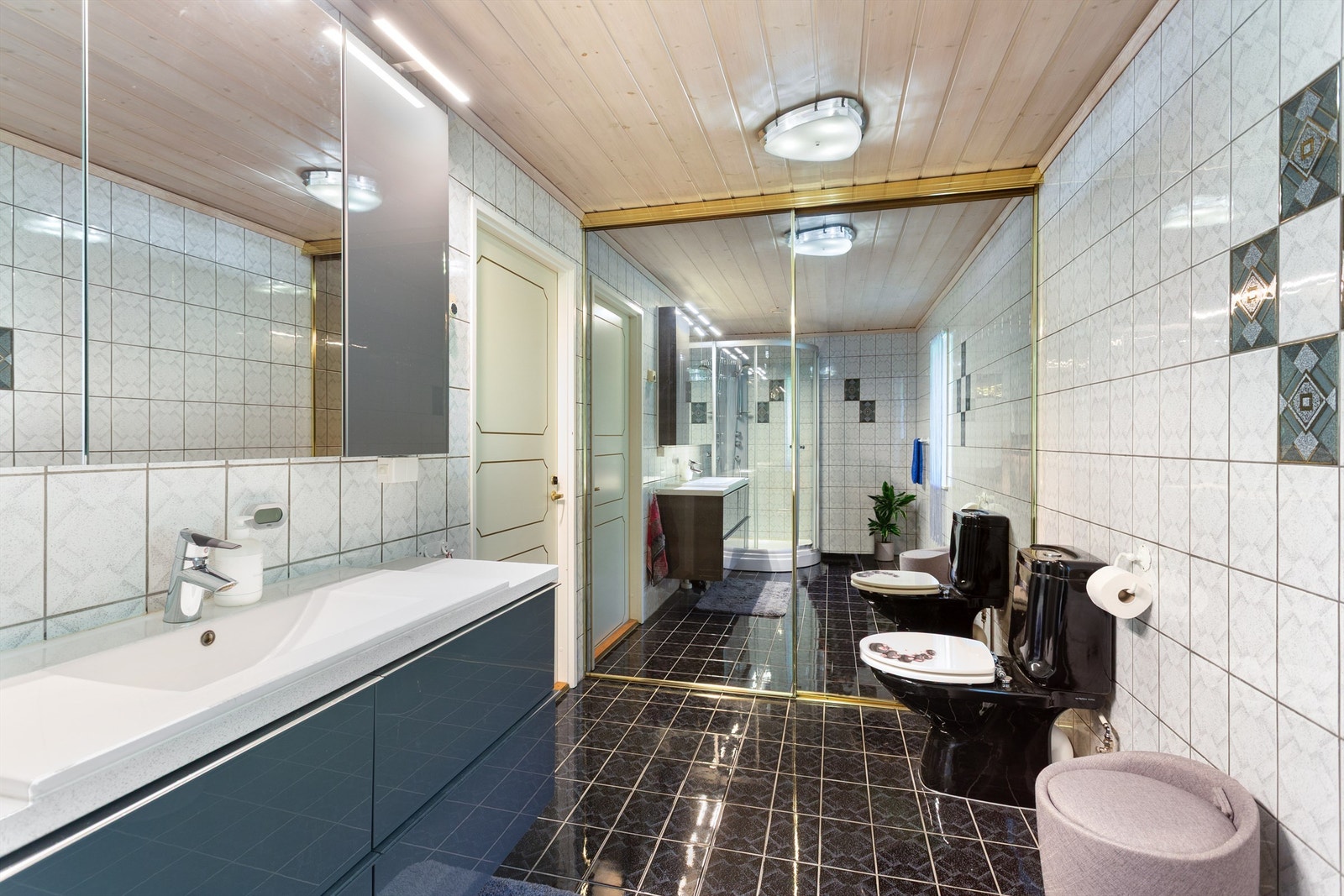Skyvedørsgarderobe med speilfronter. Videre er badet utstyrt med gulvstående toalett og dusjkabinett. Galleribilde