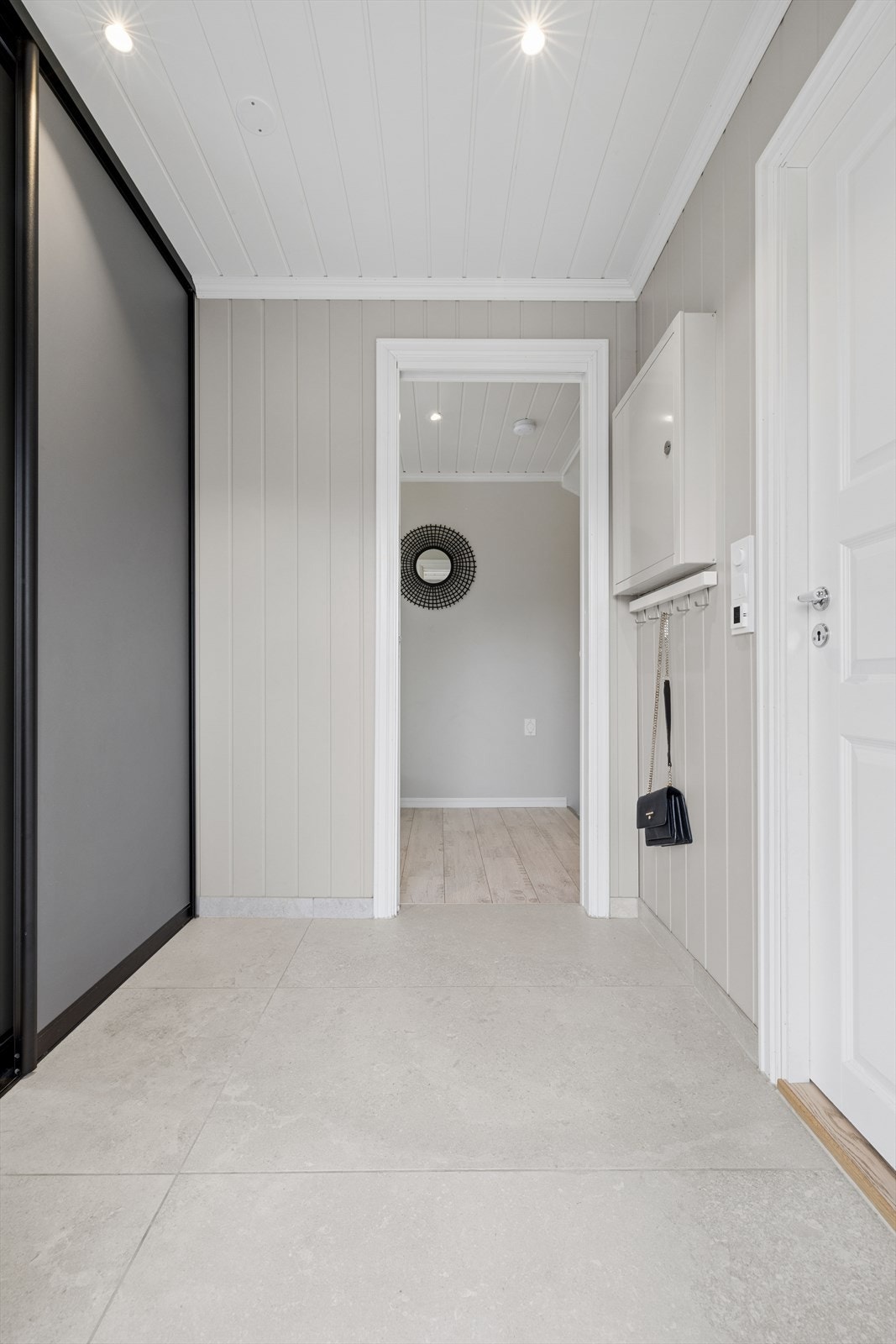 Du kommer inn i en lys og innbydende gang med fliser på gulv og godt med lagring i skyvedørsgarderobe. Galleribilde