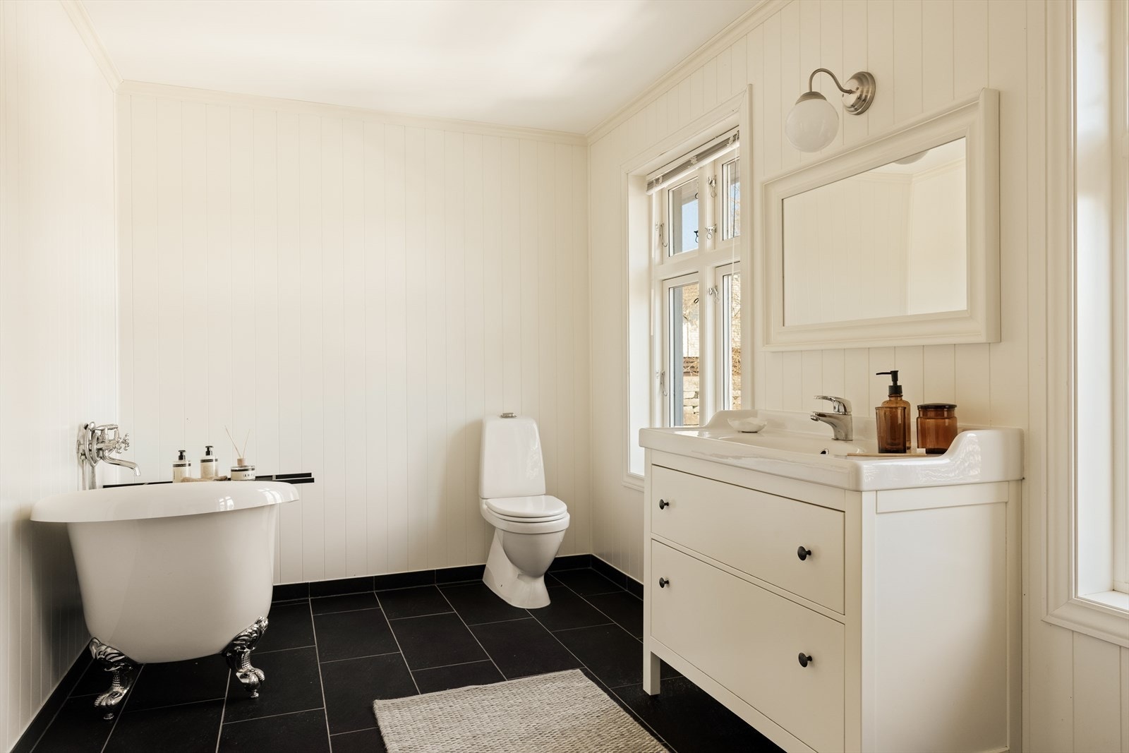 Badet er innredet med et elegant badekar på dekorative løveføtter, som tilfører rommet et særpreget og stilfullt uttrykk. Galleribilde