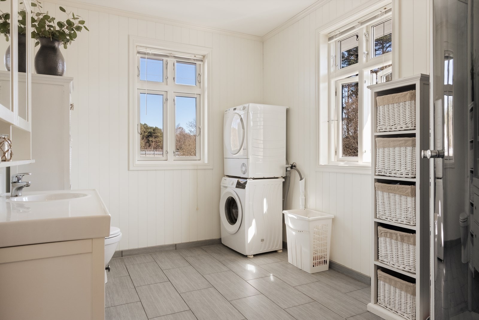Badet inneholder servant, skap og dusjkabinett. Det er også opplegg for vaskemaskin. Galleribilde