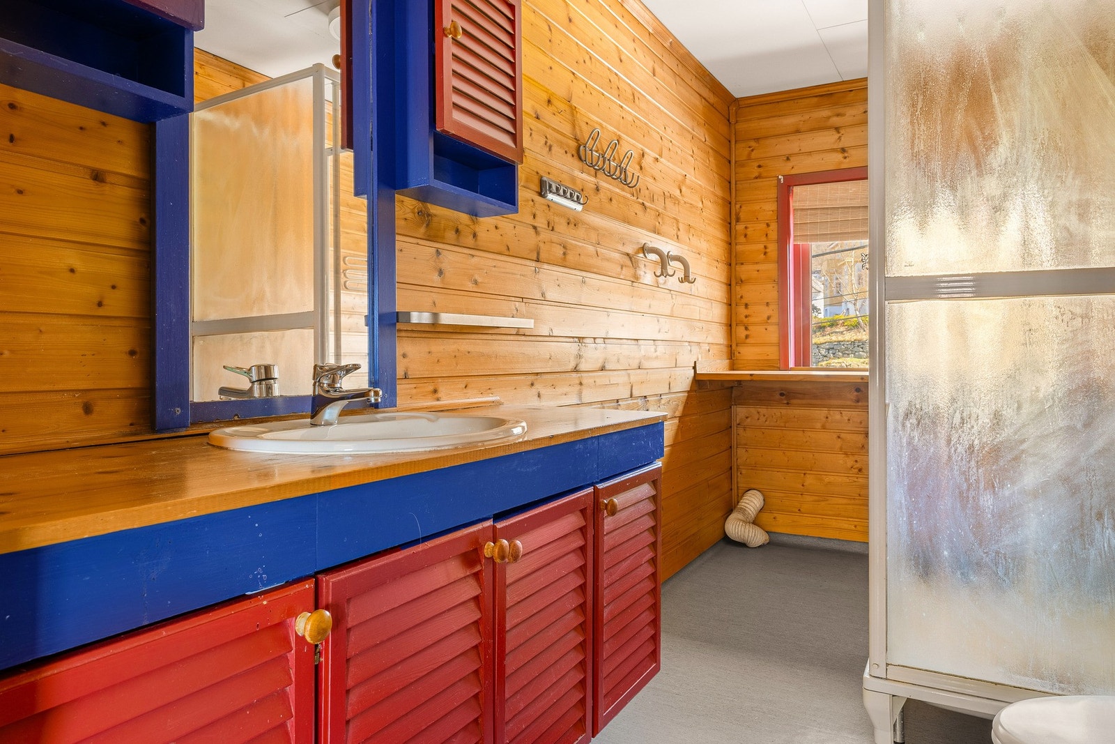 Belegg på gulv, panel på vegger og takplater i himling.
Badet er innredet med: Toalett, baderomsinnredning,
dusjkabinett og opplegg for vaskemaskin. Galleribilde