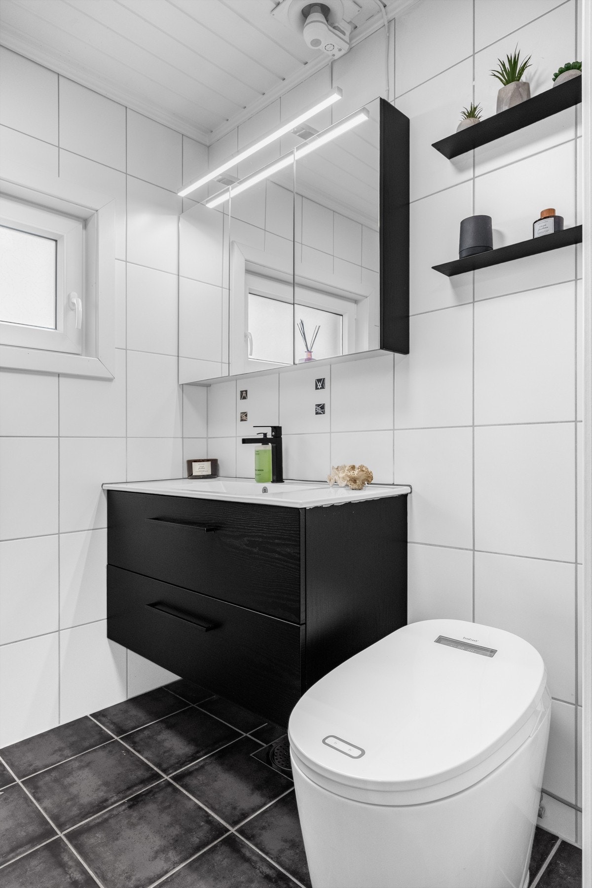 Badet er innredet med vegghengt servantinnredning med skuffer og heldekkende servant, samt speilskap med integrert belysning. Galleribilde