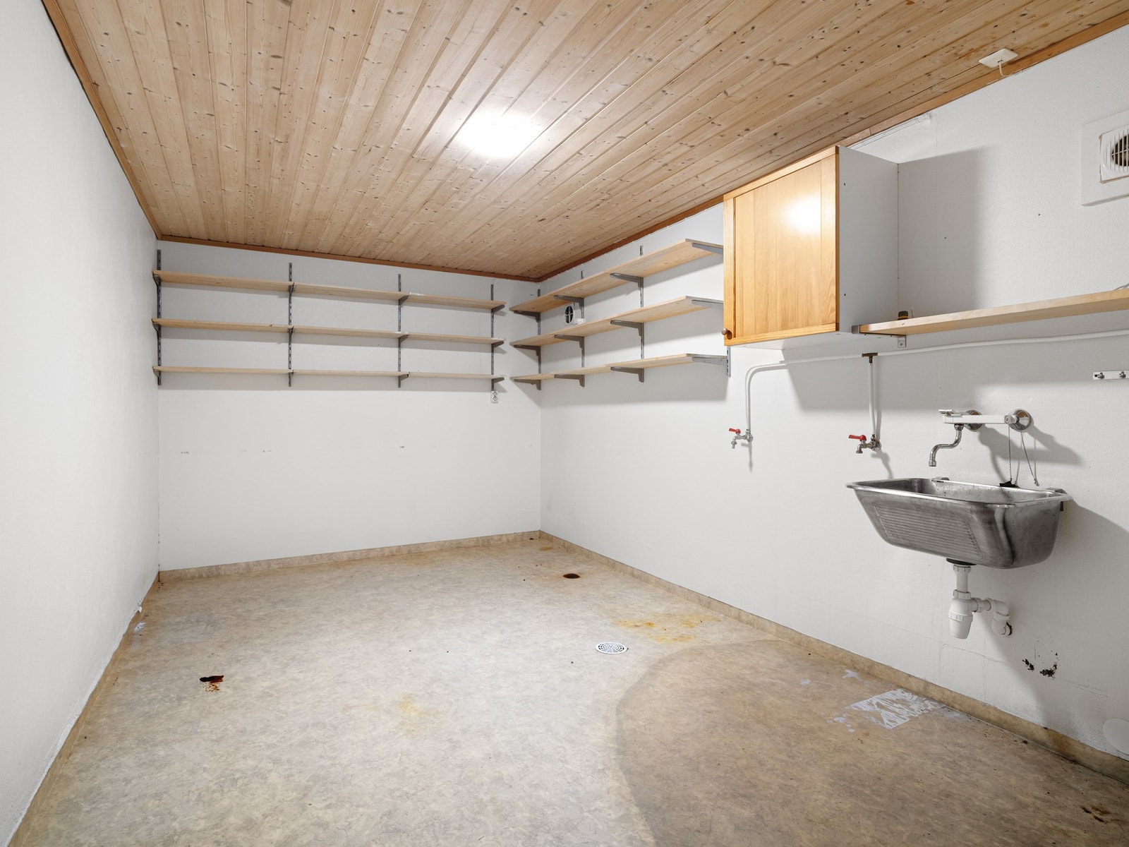 I kjelleren har boligen også et vaskerom med oppforet gulv med belegg og malt strie på vegg. Galleribilde