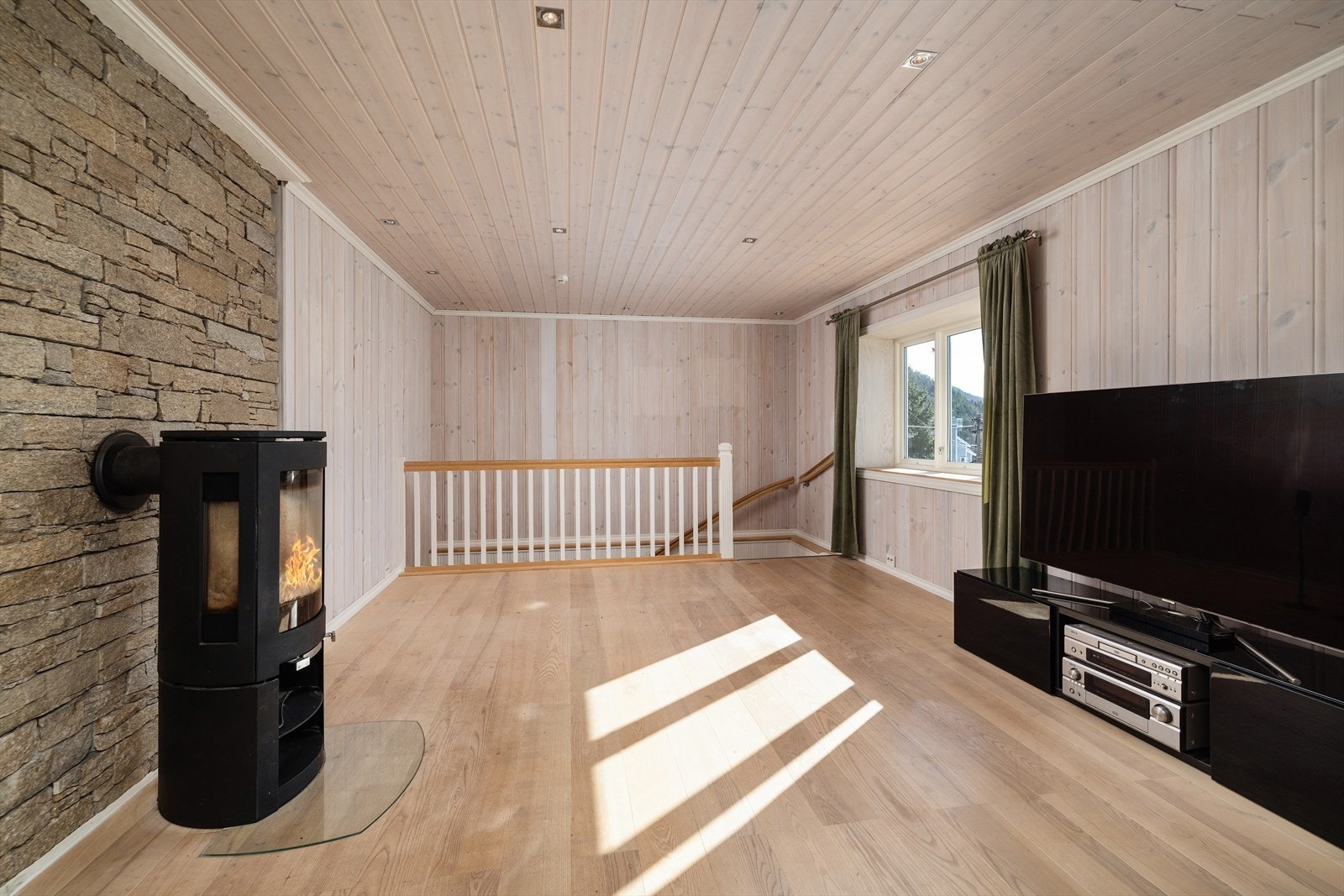Lyse overflater, downlightsbelysning og peisovn. Galleribilde