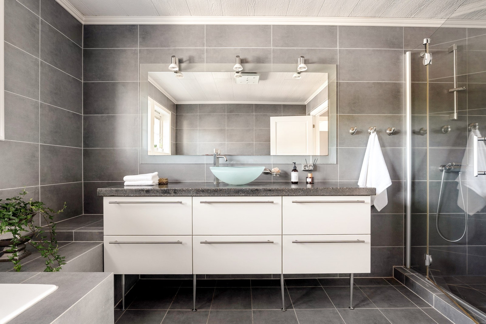 Badet er stilfullt med designpregede møbler og harmonerende fliser på gulv og vegger. Alderen betyr imidlertid at enkelte tiltak anbefales, beskrevet i tilstandsrapport. Galleribilde