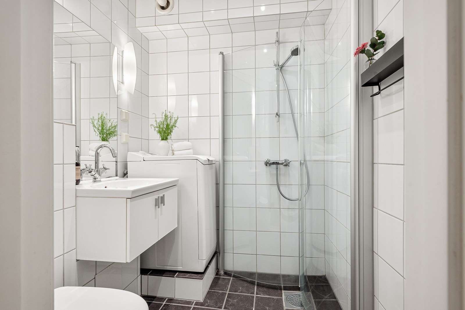 Baderommet er utstyrt med mekanisk avtrekk, opplegg for vaskemaskin, servantskap og veggmontert wc Galleribilde