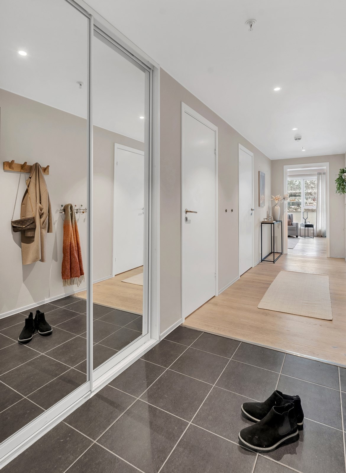 Velkommen inn! Innbydende entré med flislagt gulv, gulvvarme og garderobe for både oppheng og oppbevaring av yttertøy og sko. Galleribilde