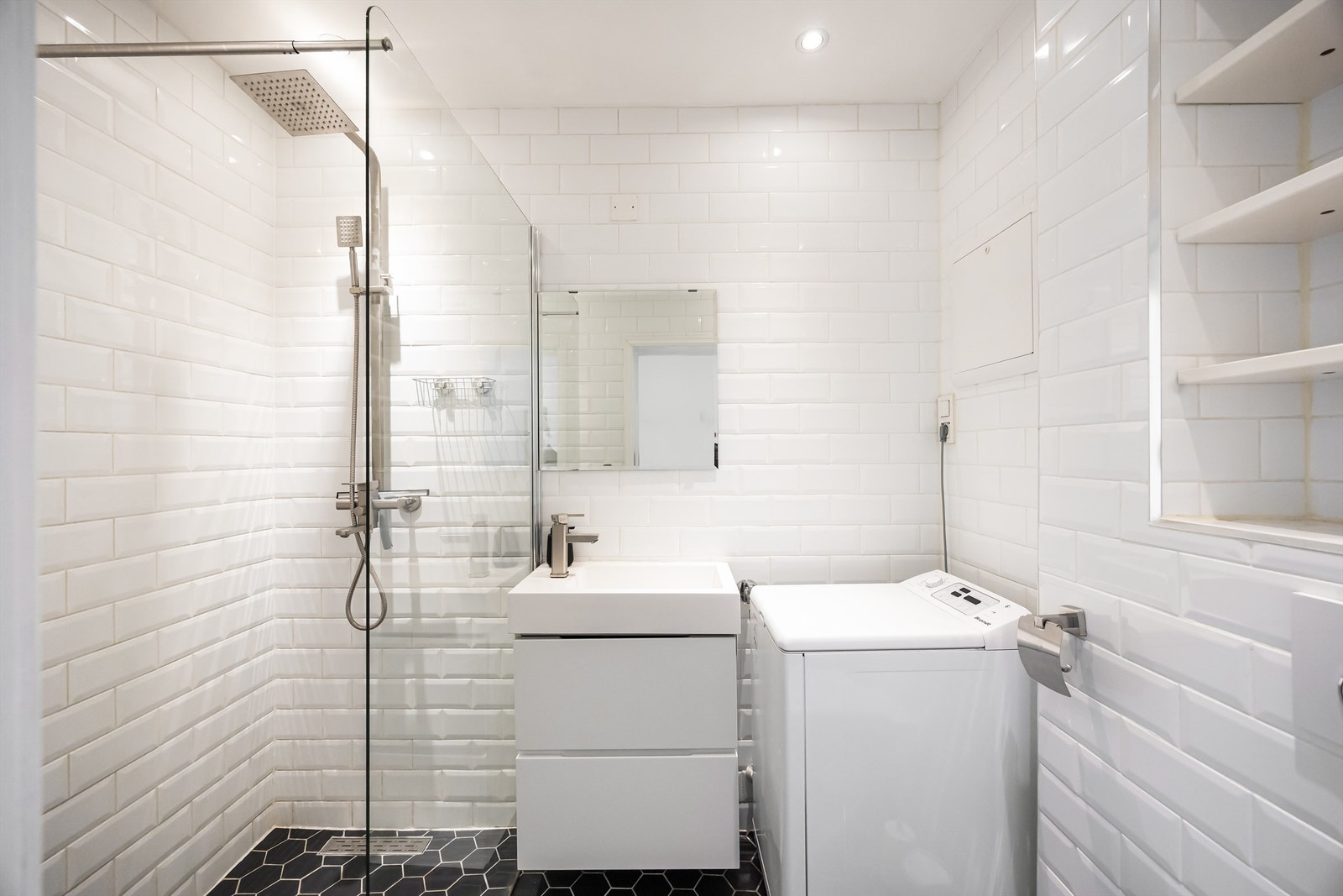 Badet er innredet med vegghengt servant og speil over servant. Galleribilde