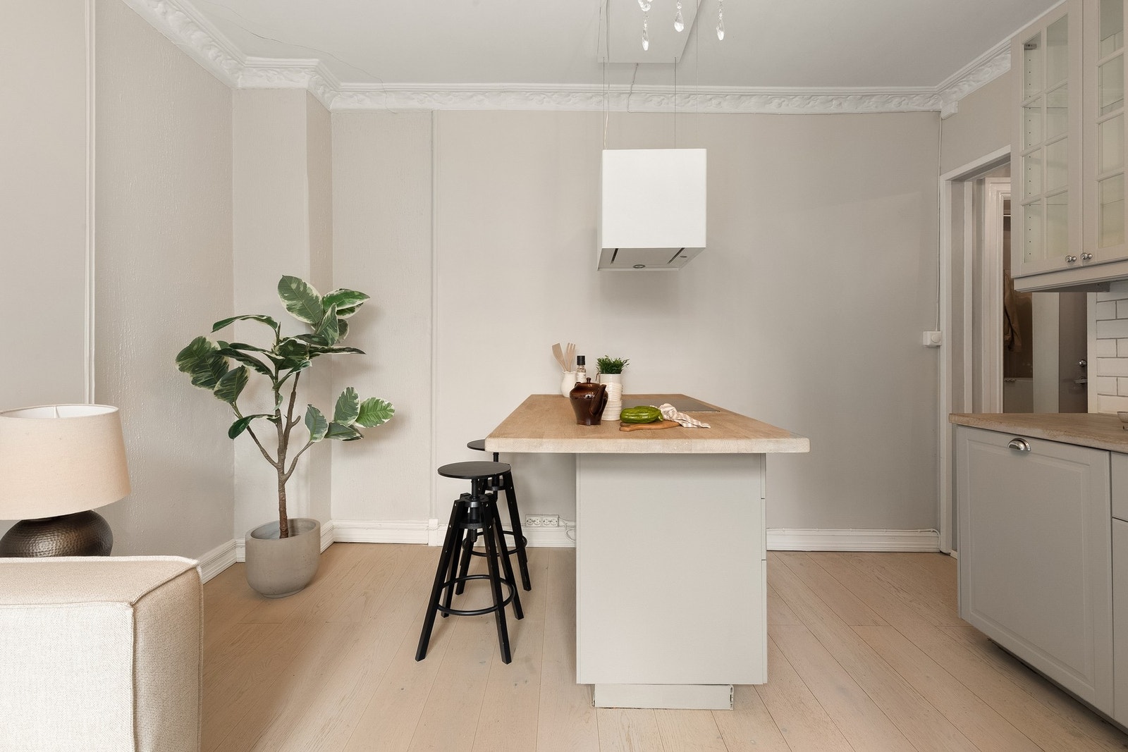 Stilren kjøkkeninnredning som består av malte profilerte fronter og en benkeplate i tre med fliser over. Galleribilde