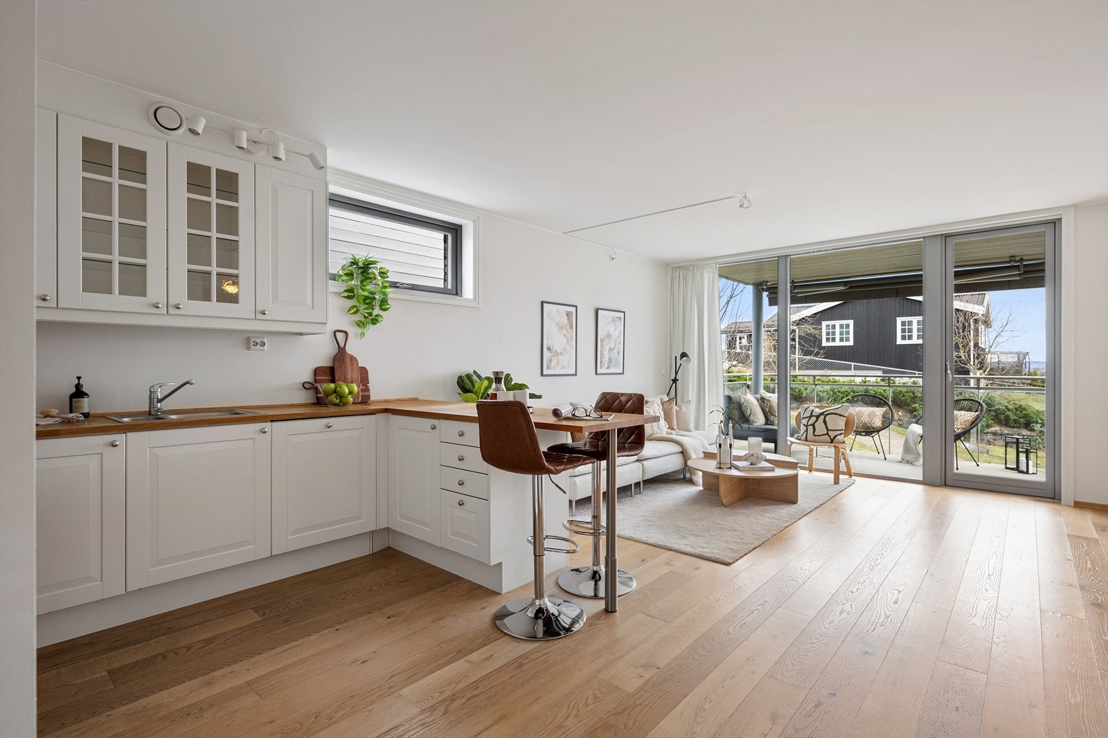 Den åpne løsningen mot stuen gjør kjøkkenet til et sosialt og naturlig midtpunkt i leiligheten - perfekt for de som liker å lage mat mens gjestene er til stede. Galleribilde