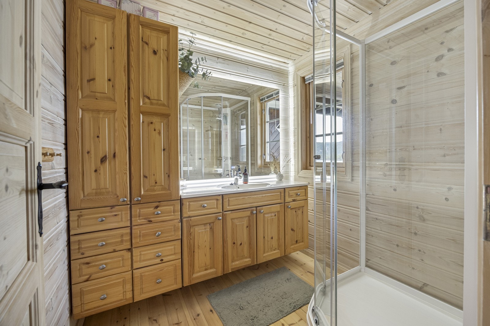 Badet er innredet med romslig baderomsinnredning med speil med lys. I tillegg dusjkabinett. Galleribilde
