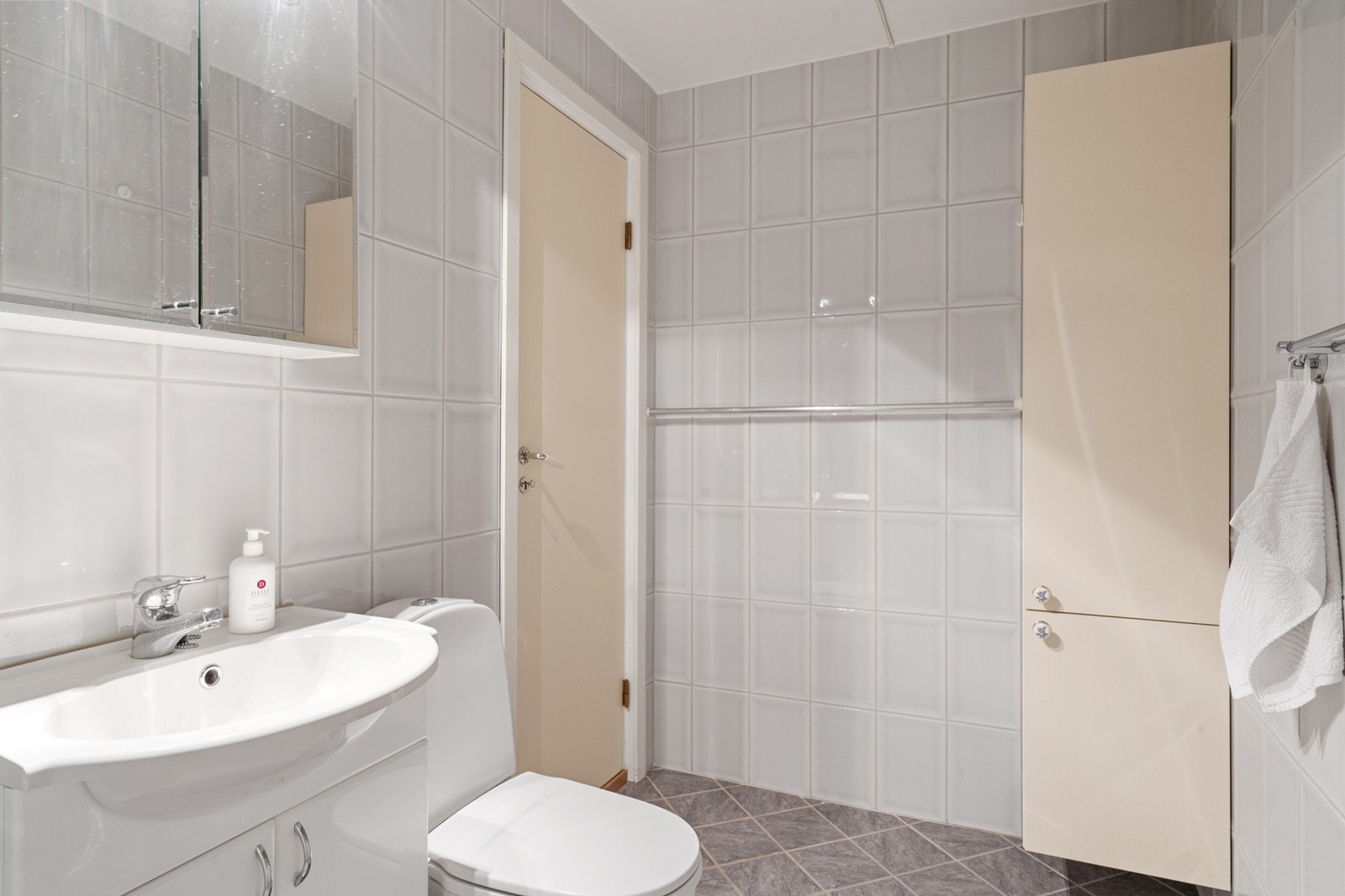 Badet i sokkeletasjen er innredet med servantmøbel, høyskap, speilskap og dusjhjørne med glassdører. Galleribilde